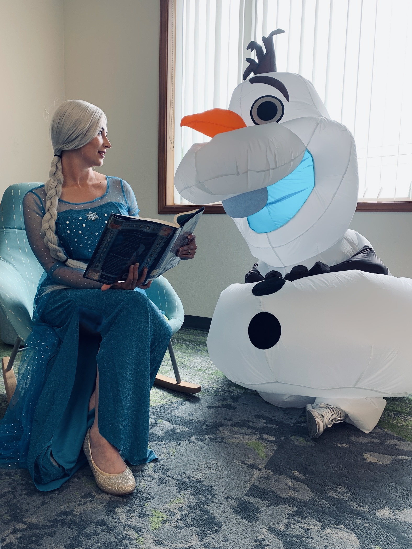 A storybook ice queen reads a book to a snowman.