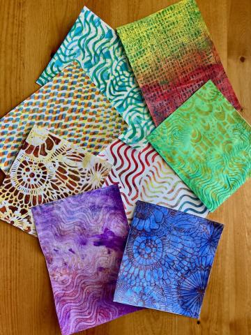 Patterned prints on paper created using gel plates and stencils.