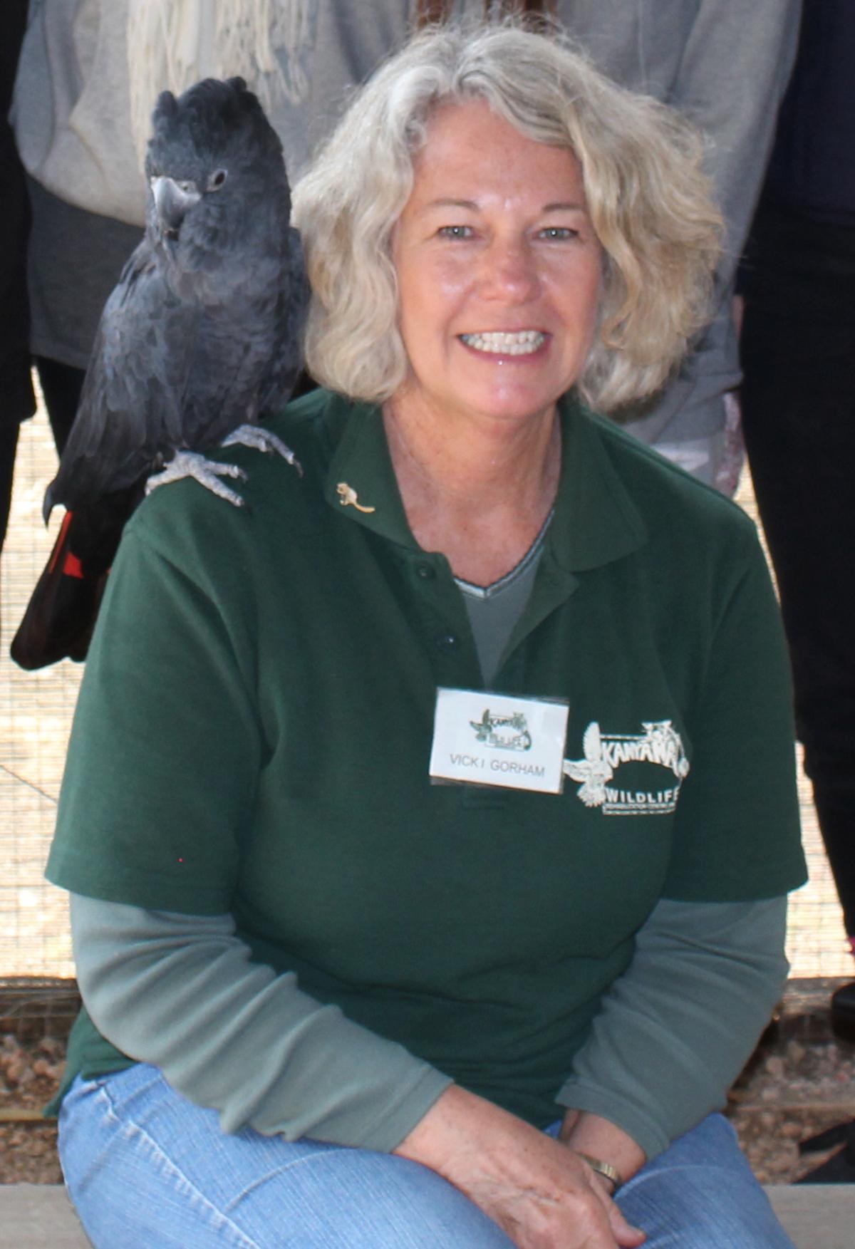 Photo of Vicki Gorham with a black cockatoo on her shoulder